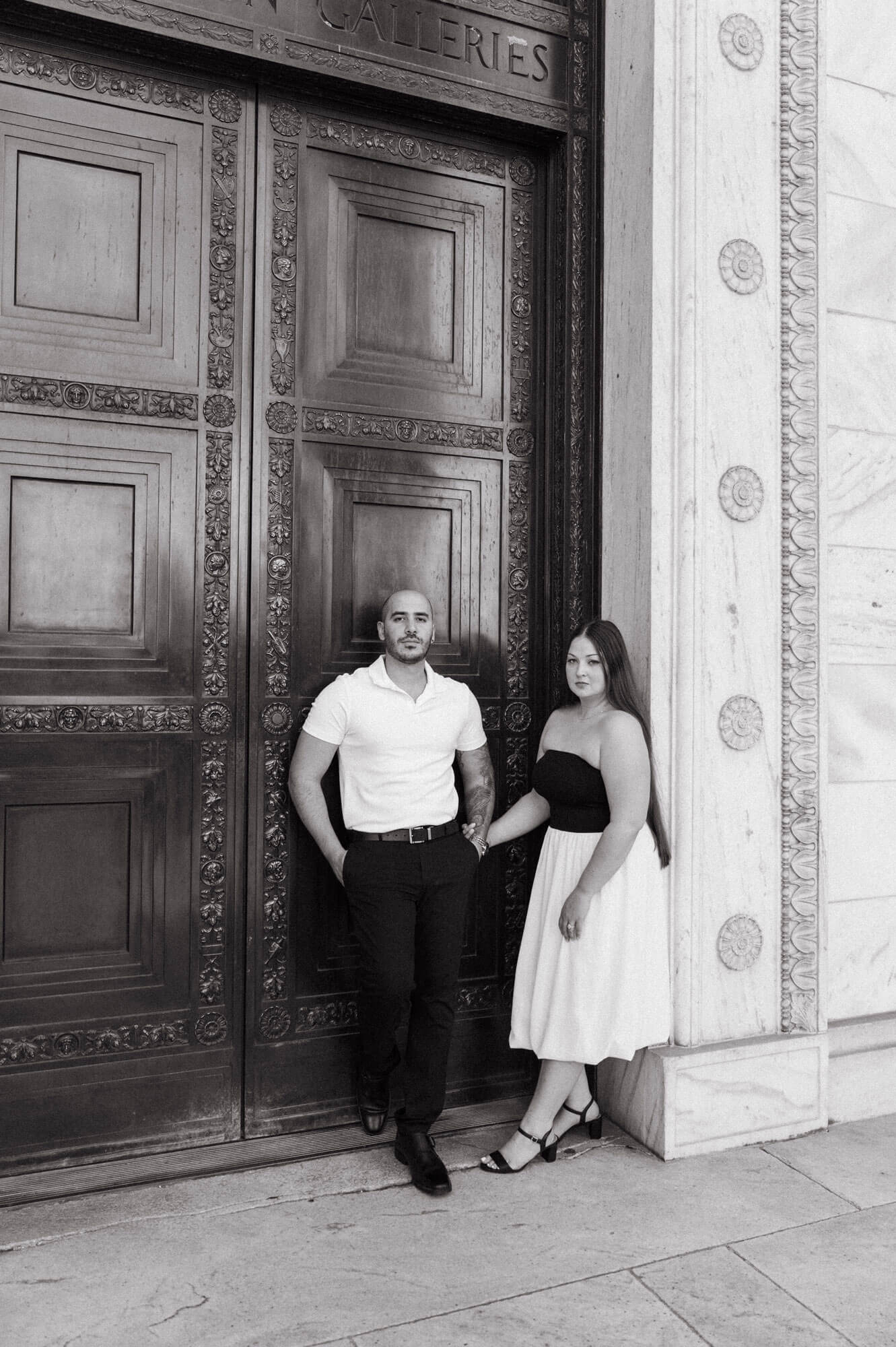 Couple standing together in front of the Huntington Galleries entrance.