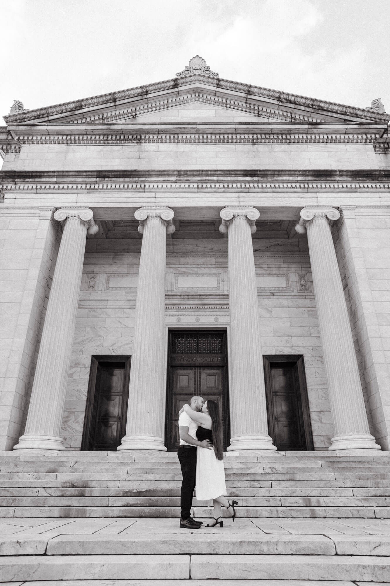 Couple embracing on the museum steps beneath the columns.